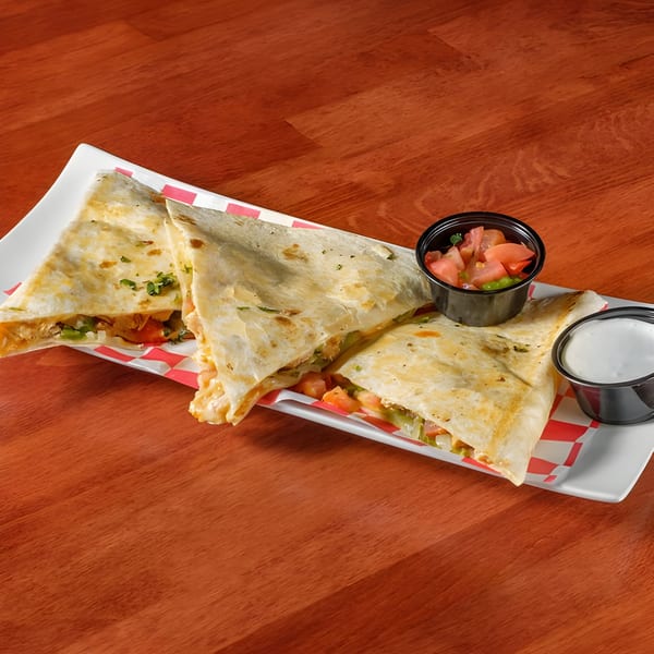 Three quesadilla slices filled with meat and vegetables, served with salsa and sour cream.